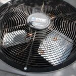 A York outdoor air compressor with leaves and pine needles sitting on top.