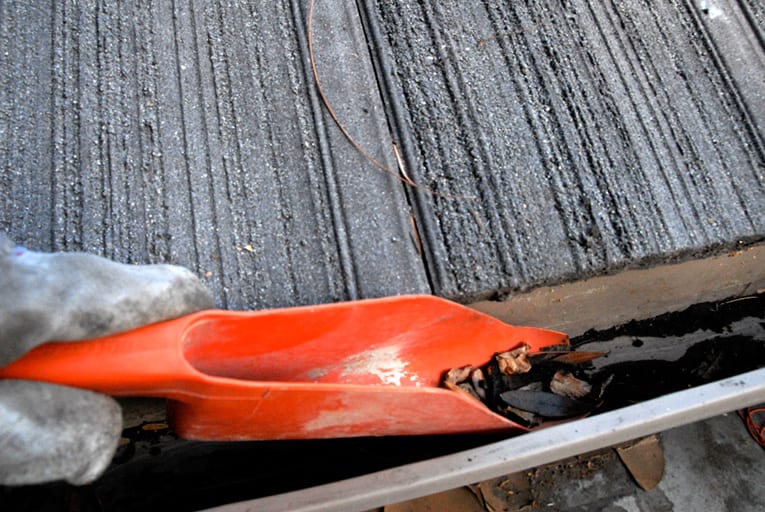 scooping debris from a gutter