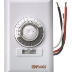Mechanical spring-wound timer switch, with electrical wirings over a white background.