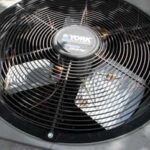 A York outdoor air compressor with leaves and pine needles sitting on top.