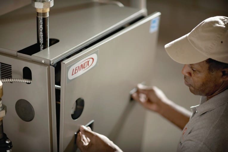 Service person doing forced-air furnace care