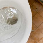 A clogged toilet filling with water