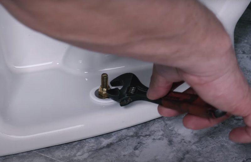 remove toilet bolts with wrench