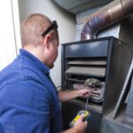 HVAC person repairing a furnace
