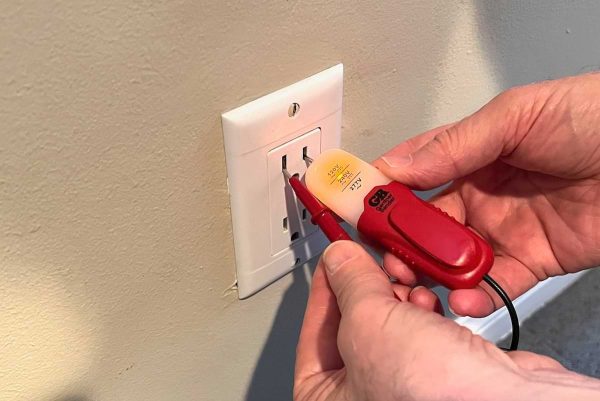 Using a circuit tester to test an outlet before replacement