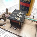 Using cotton swab to clean the electromagnet tubes with lighter fluid.