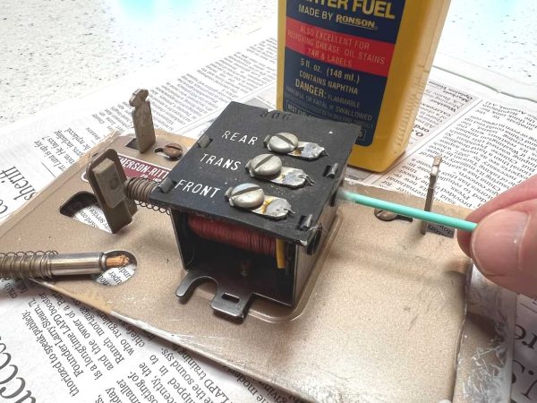 Using cotton swab to clean the electromagnet tubes with lighter fluid.